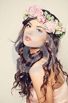 Beautiful Young Woman with Flowers. Long Curly Hair
