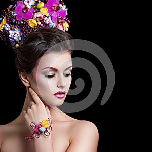 Beautiful young woman with flowers. Professional make-up and flowers in her hair.