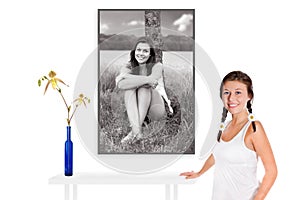 Beautiful young woman in front of a monochrome beauty portrait of herself