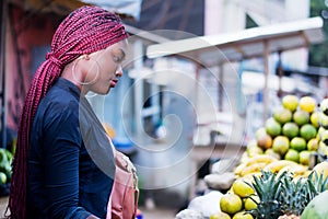 Beautiful young woman at the fruit market of the street