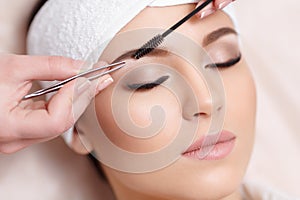 Beautiful young woman gets eyebrow correction procedure photo