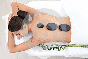 Beautiful young woman getting hot stone massage