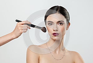 Beautiful young woman getting makeup done, beauty concept