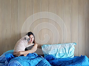 Beautiful young woman or girl cuddles and hugs her best friend pug puppy dog, sleep rest together under blankets in hipster