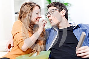 Beautiful young woman giving food to her darling front of the TV