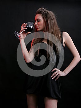 Beautiful young woman with a glass of red wine.