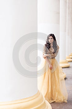 Beautiful young woman in gold dress