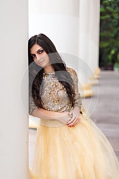 Beautiful young woman in gold dress