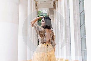 Beautiful young woman in gold dress