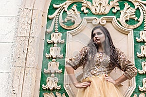 Beautiful young woman in gold dress