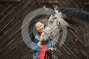 Beautiful young woman and gray horse portrait