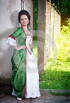 Beautiful young woman in green medieval dress