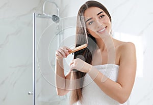 Beautiful young woman with hair brush