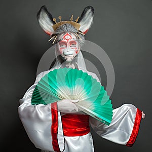 Beautiful young woman with Halloween makeup and rabbit mask on black background