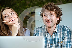 Beautiful young woman and handsome man using laptop