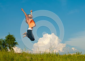 Beautiful young woman happy jumping on blue sky