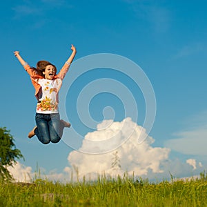 Beautiful young woman happy jumping on blue sky