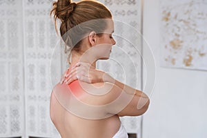 Beautiful young woman has neck pain. Female suffering from painful feeling in muscles, holding hands on her neck. Health