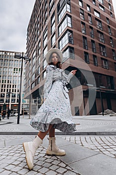 beautiful young woman in a hat and light dress near the mall. purchases. shopping