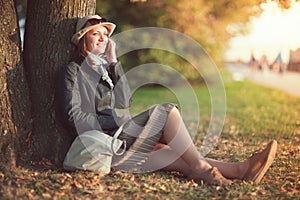 Beautiful young woman in hat and scarf with mobile phone in the