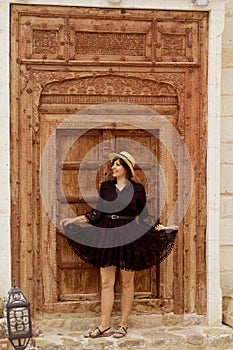 beautiful young woman in a hat standing front of the door in cappadocia, turkey