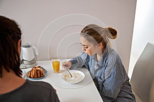 Beautiful young woman having breakfast with boyfriend at home