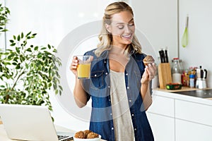 Beautiful young woman having breakfast in the kitchen.