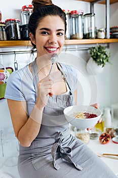 Beautiful young woman having breakfast in the kitchen.