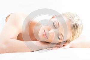 Beautiful young woman having leisure lying in a mat in spa