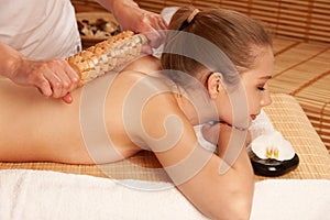 Beautiful young woman having a maderotherapy massage treatment in spa salon - wellness photo