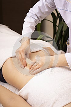 Beautiful young woman having stomach massage.Vertical photo