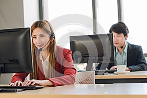 Beautiful young woman in headphones with microphone consulting client on phone in customer support service