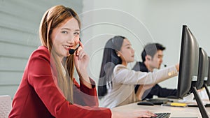 Beautiful young woman in headphones with microphone consulting client on phone in customer support service