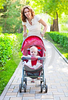 Beautiful young woman with her child in a baby carriage