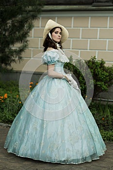 A beautiful young woman in a historical blue dress 1860 year. Book cover design.