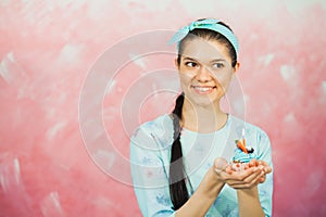 Beautiful young woman holding birthday cupcake and making wish