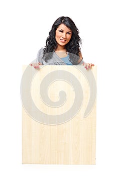 Beautiful young woman holding a blank wooden board
