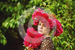 Beautiful young woman with peony flowers