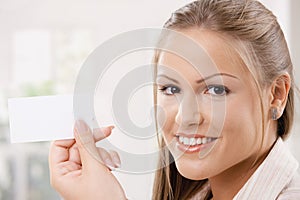 Beautiful young woman holding card