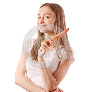 Beautiful young woman holding a carrot in the hands