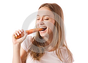 Beautiful young woman holding a carrot in the hands