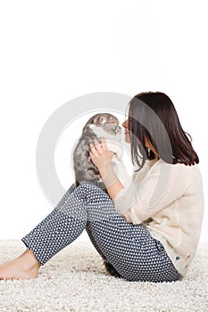 Beautiful young woman holding a cat, isolated against white background