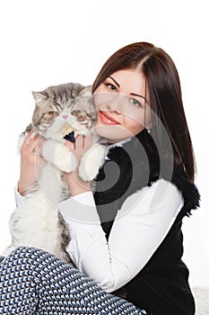Beautiful young woman holding a cat, isolated against white background