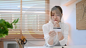 Beautiful young woman holding credit card. Online shopping, internet banking concept