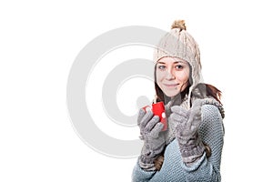 Beautiful young woman holding a cup of tea and showing thumbs up