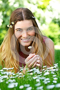 Beautiful young woman holding flower in the park