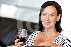 Beautiful young woman holding glass with red wine