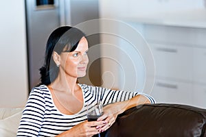 Beautiful young woman holding glass with red wine