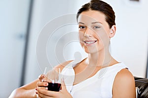 Beautiful young woman holding glass with red wine