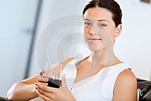 Beautiful young woman holding glass with red wine